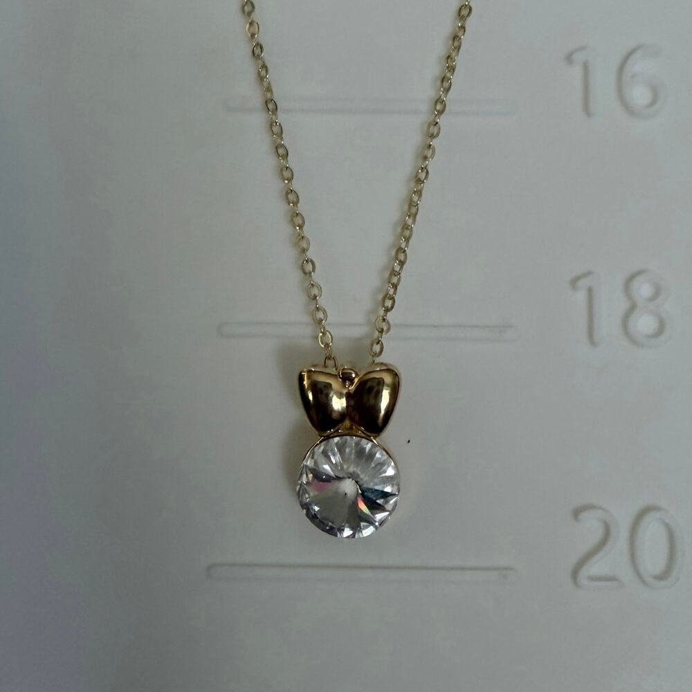 Womens gold tone, 20” necklace with bow & clear Swarovski crystal pendant EUC